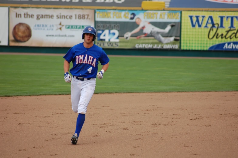 a baseball player in blue running across a field