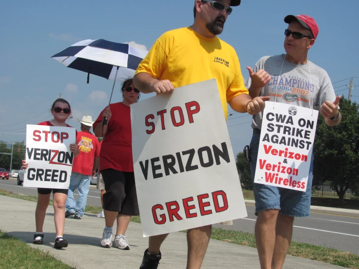 several people with protest signs standing on the street