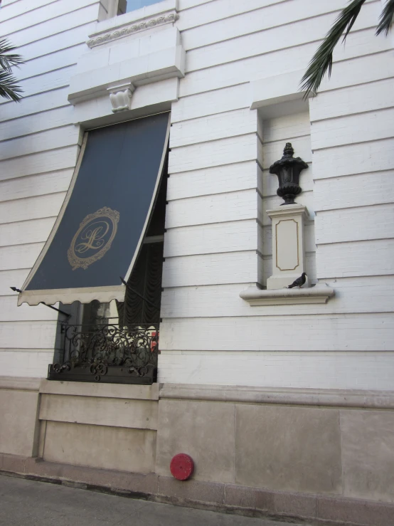 the side of a white building with a decorative window