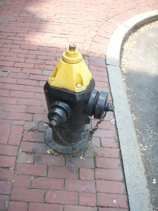 a yellow and black fire hydrant sits on the sidewalk