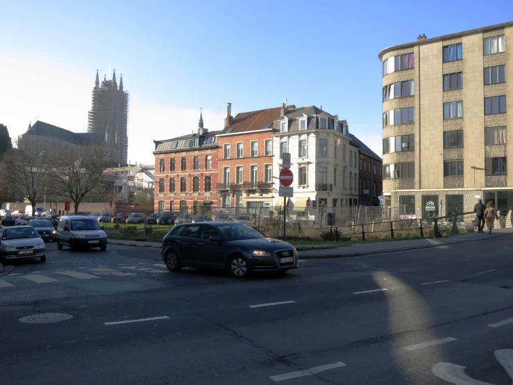 cars wait at the edge of a busy city street