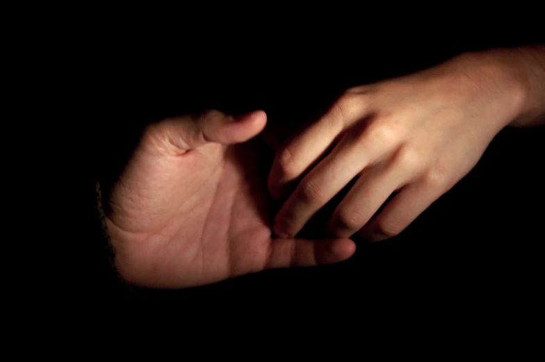 a persons hand grabbing the camera out in the dark