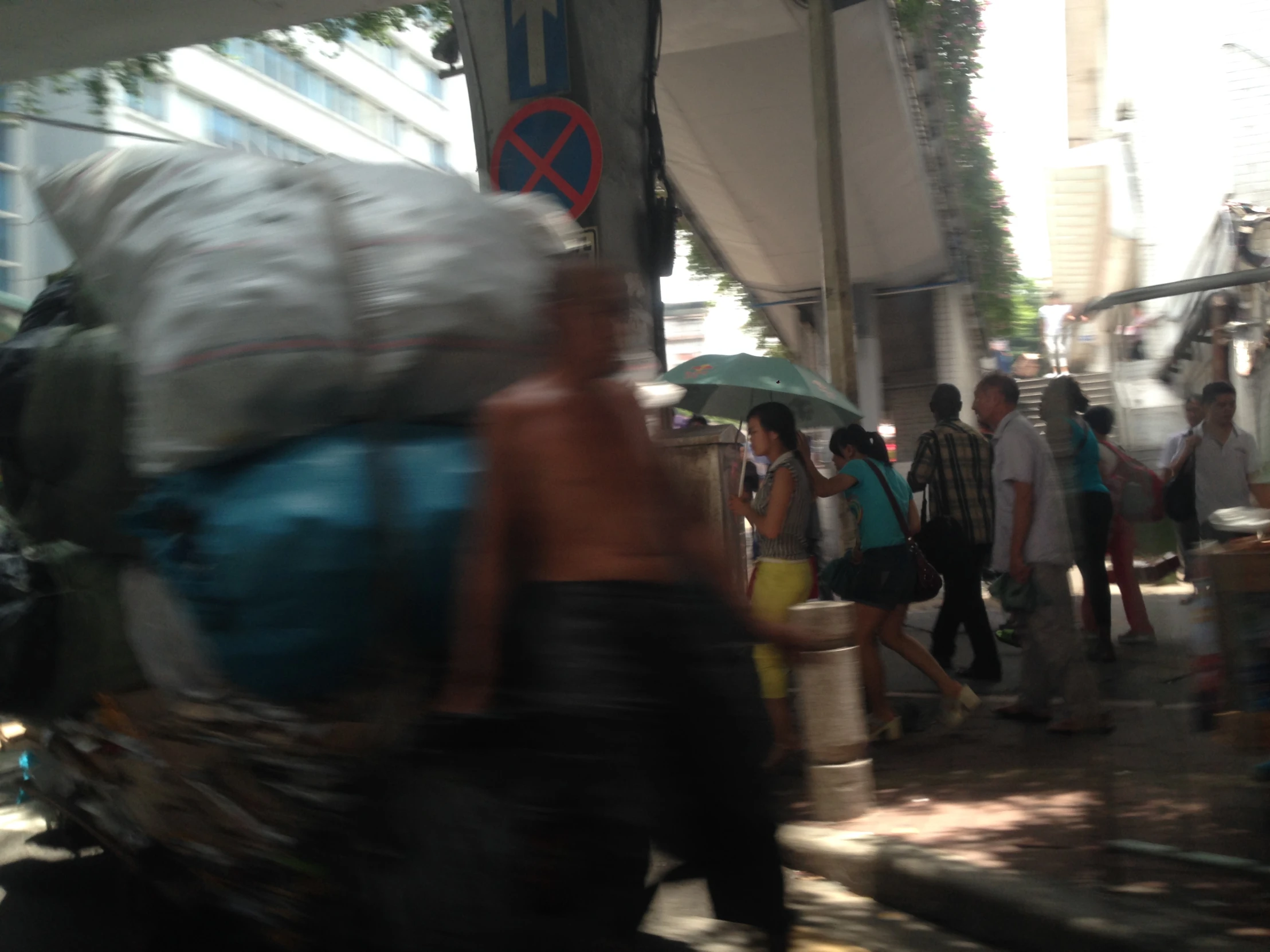 people are walking in the street carrying large bags