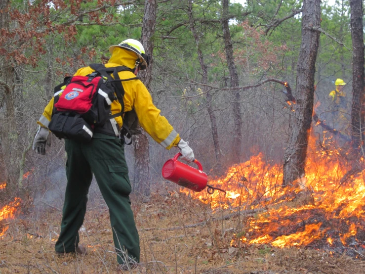 the fireman is watching as he holds a water bottle