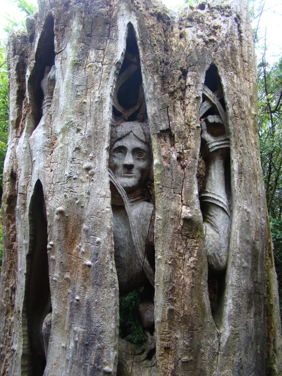 several stone sculptures of people on display in the rocks