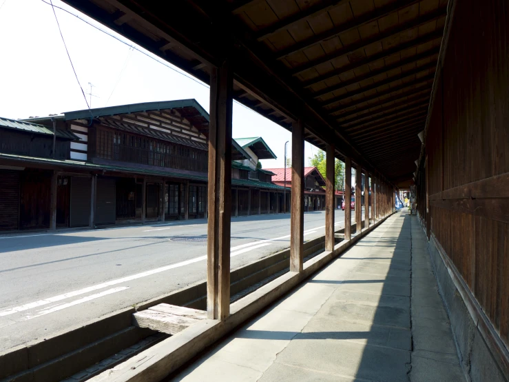 a row of wooden buildings sitting next to a long sidewalk