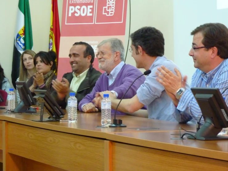 a group of people sitting around a table in a meeting