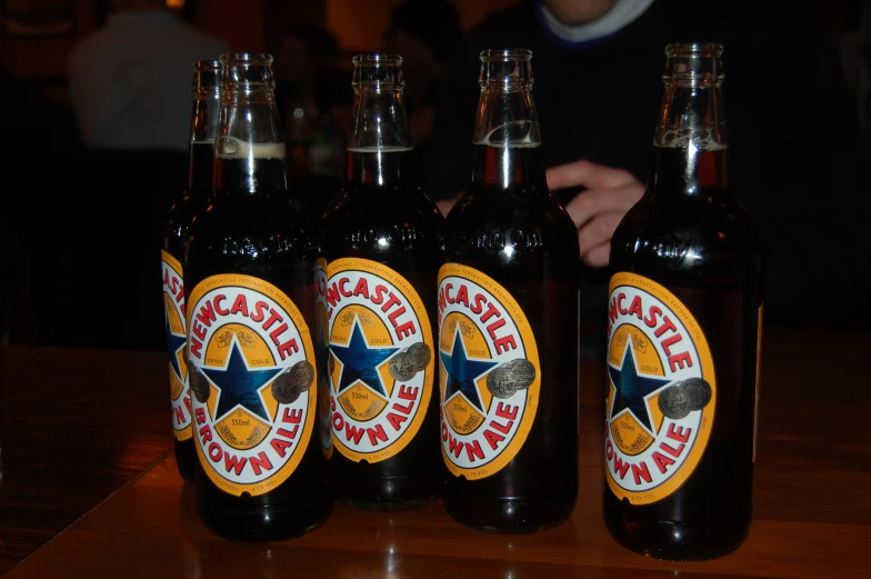 three black beer bottles on a wooden table