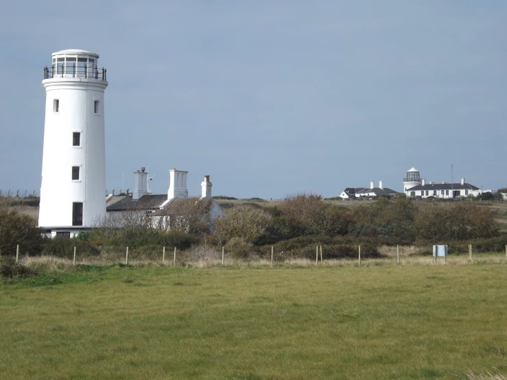 a large white lighthouse is out in the open