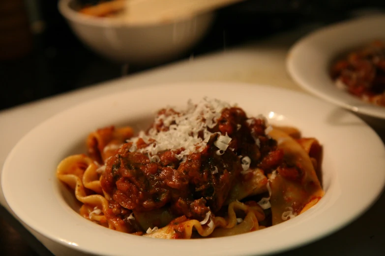 pasta sauce in bowl with shredded parmesan on top