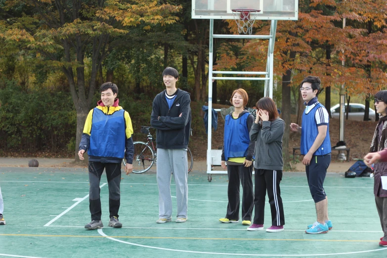 boys and girls standing in front of a basketball hoop with their hands on their hipss