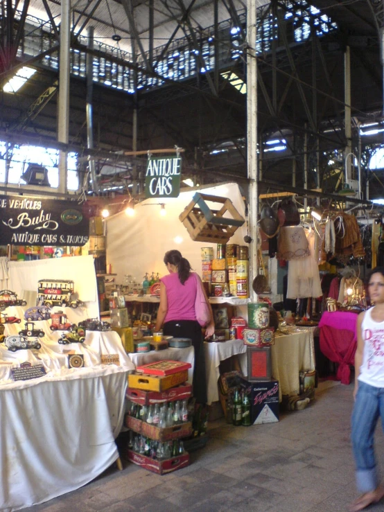 people walking around an outdoor market with food on display