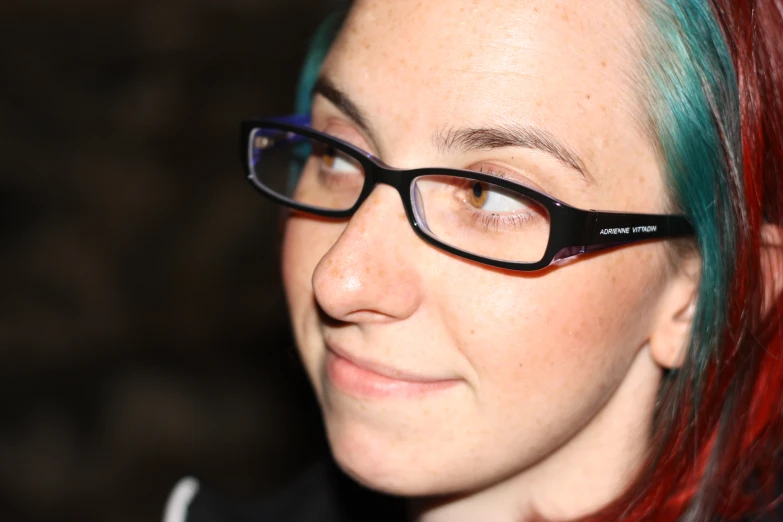 a woman with a blue and green hair, glasses on