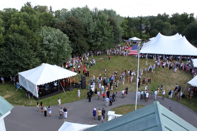 a large crowd of people walking near a tent