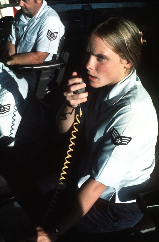 a female professional on a phone is seated and looking away