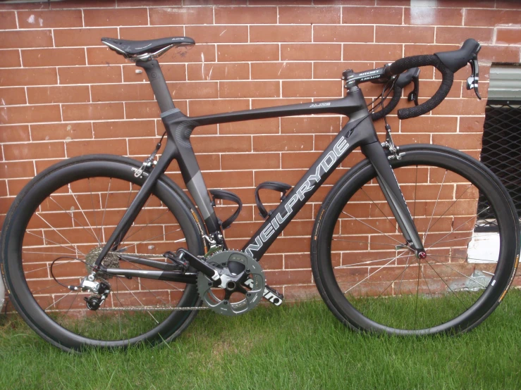 a silver and black bike in front of a brick building