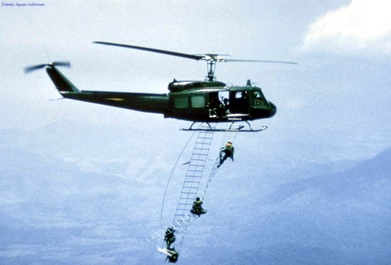 a helicopter is being hoisted by people on ladders