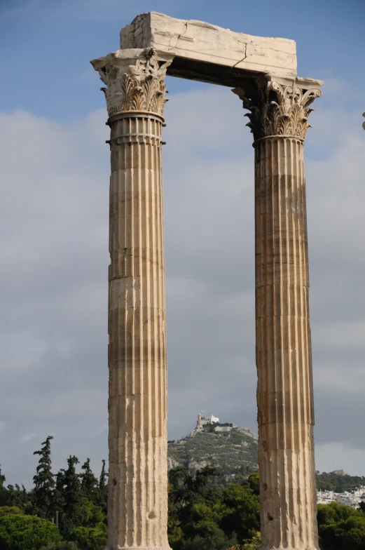 two old pillars sitting side by side in a park