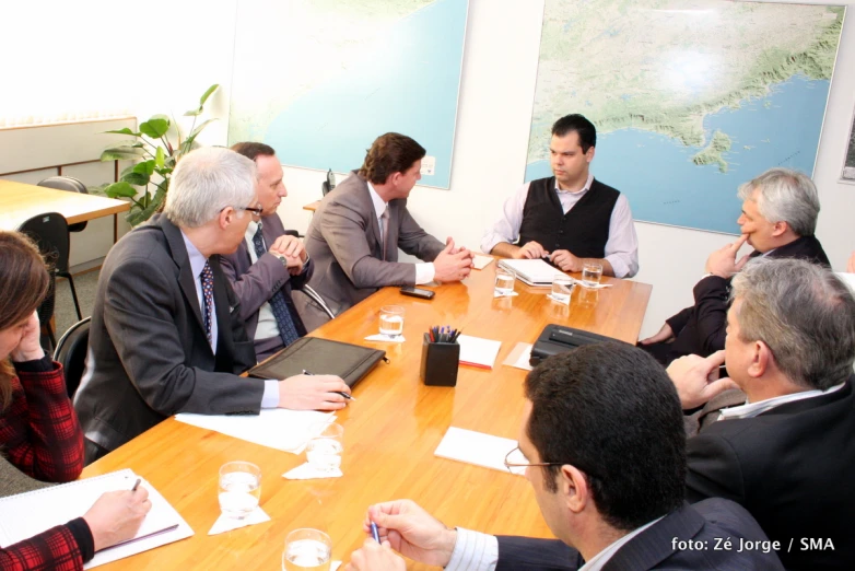 several people sit around a table discussing soing