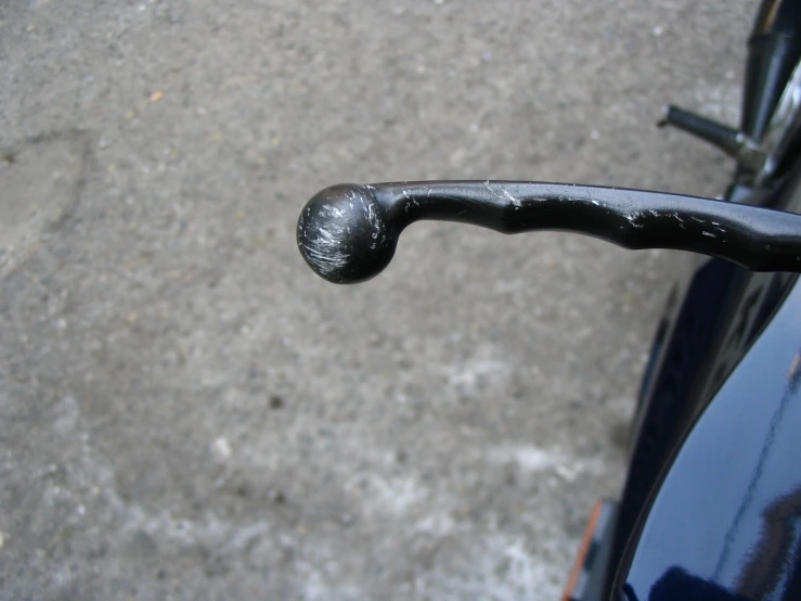 a close up of a shiny black bicycle handlebar