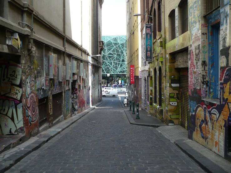 an alleyway with graffiti on the walls and a car parked by