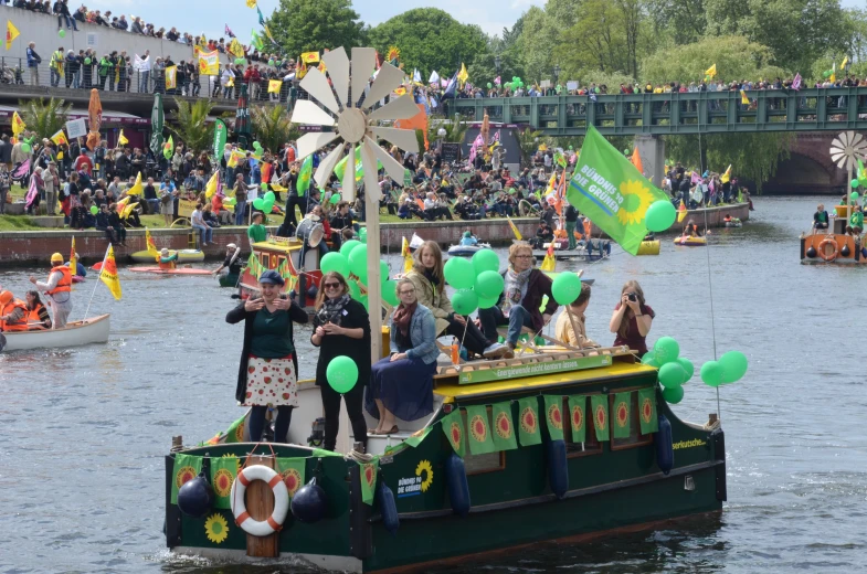 people gathered on a boat with balloons floating in the water