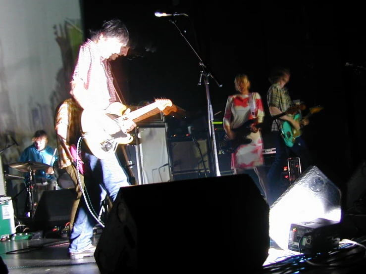 man with guitar playing on stage at an event