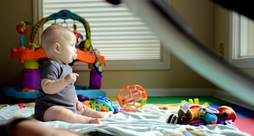 a baby sitting in a chair with toys