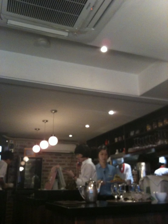 several people behind the bar at a cafe