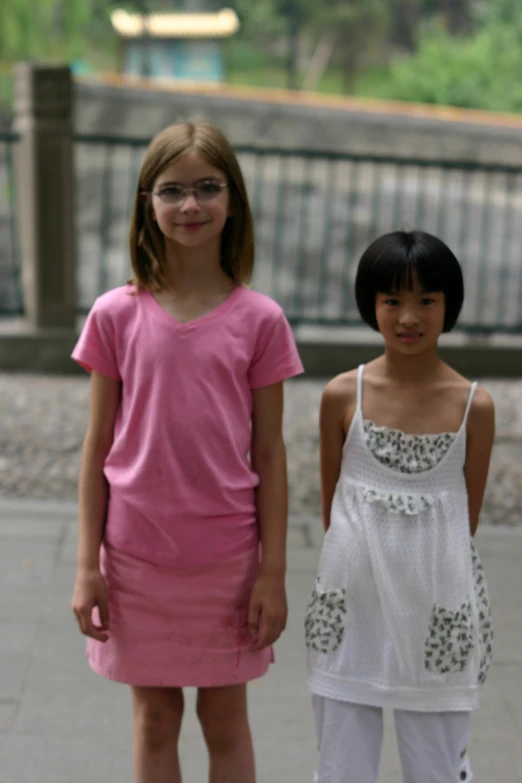 two girls in pink outfits pose for a po