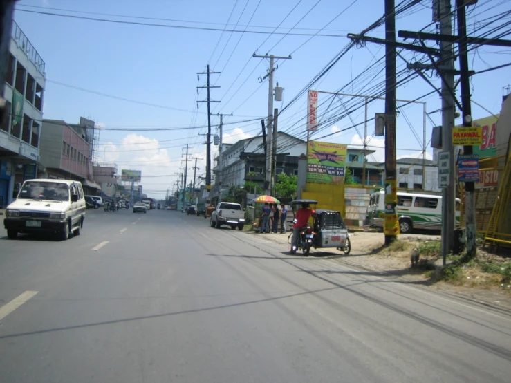 an empty street with a motorcycle and cart parked on the side