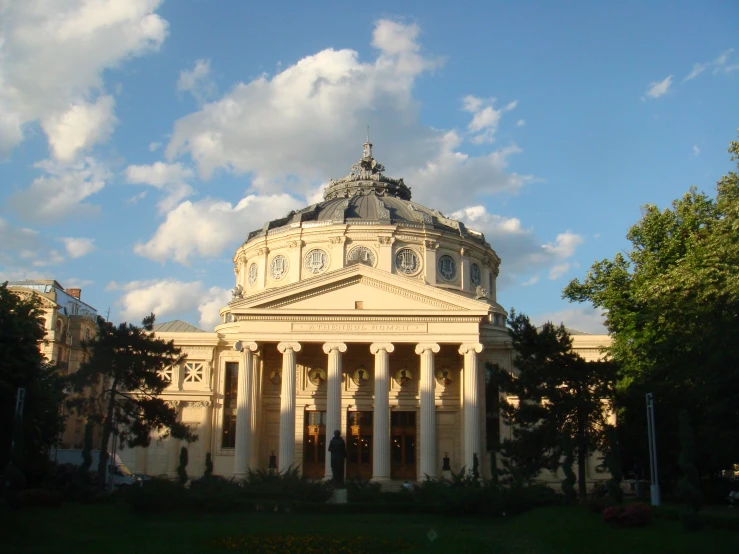 a large building sits on top of a lush green field