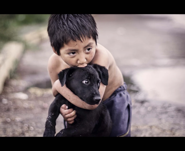 a little boy is cuddling up with his dog