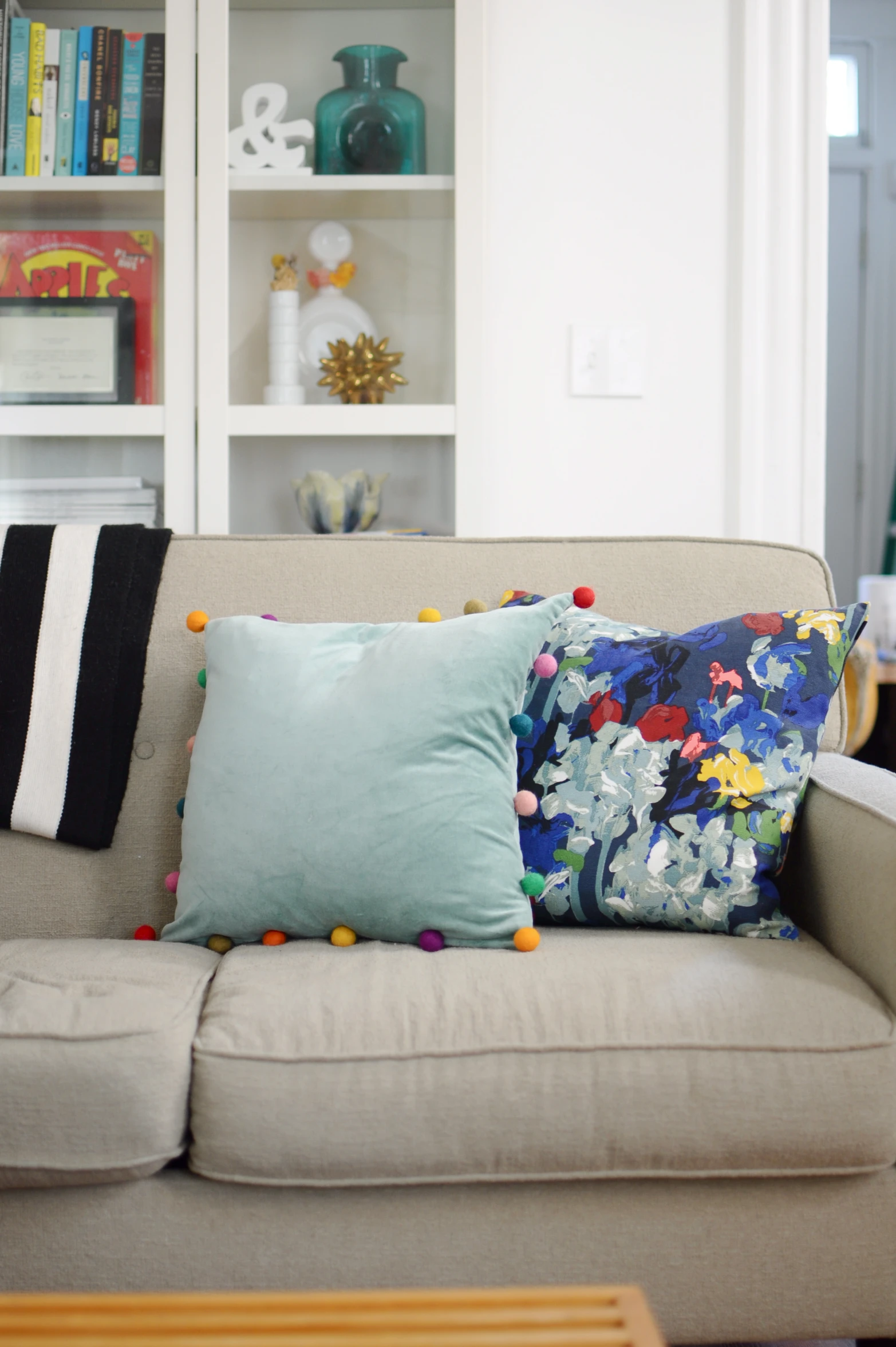 a couch covered with pillows and pom - poms
