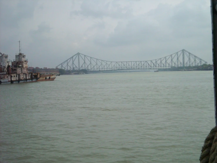 a view of a bridge across a river with docked ships below