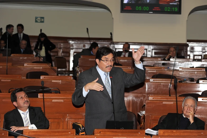 a man is speaking at a meeting in a lecture hall