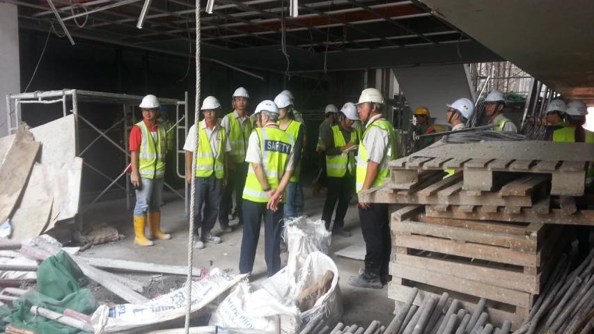 group of people in safety jackets standing on a site