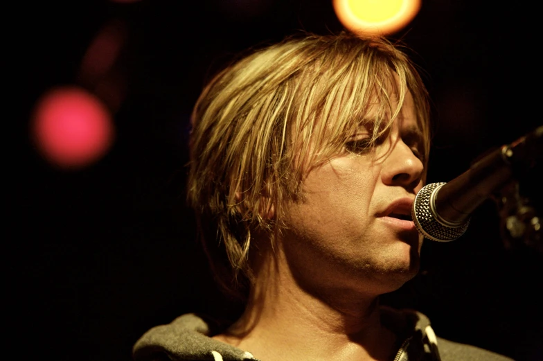 a male singing into a microphone in a black shirt