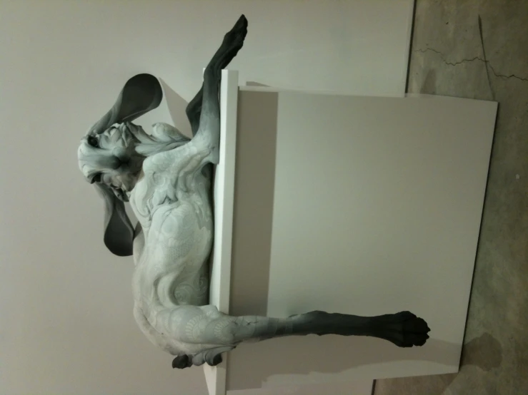 a dog is laying down on the top of a sculpture