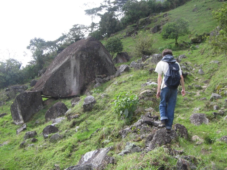 a man walks up the side of a hill