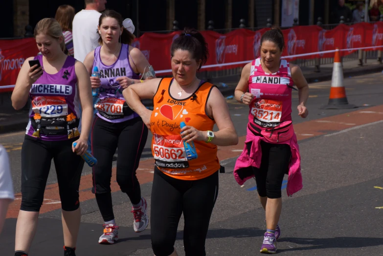 group of runners dressed in sports clothing on street