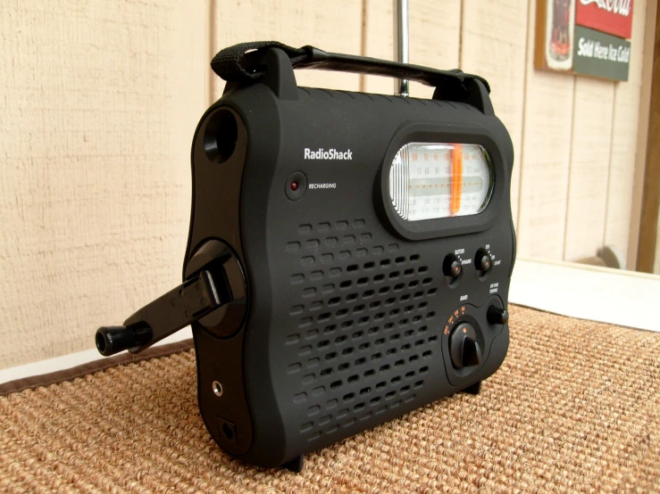 a black radio sits on the ground near a sign