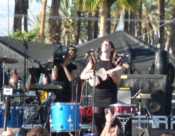 two woman stand and sing on stage