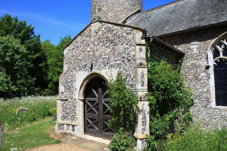 a old stone church with ivy growing around the doorway