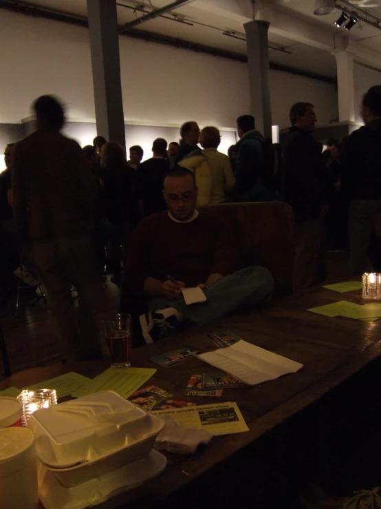 a group of people sitting around a table with many candles on it