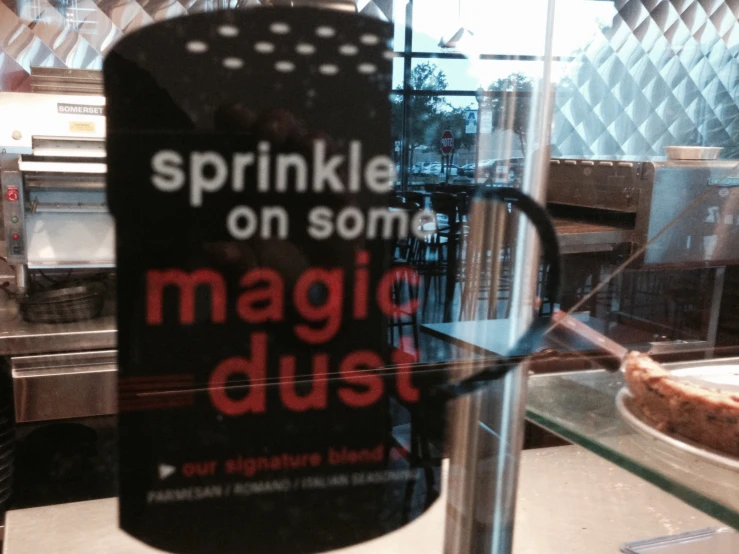 a sign advertising magic dust, behind the glass of a bakery