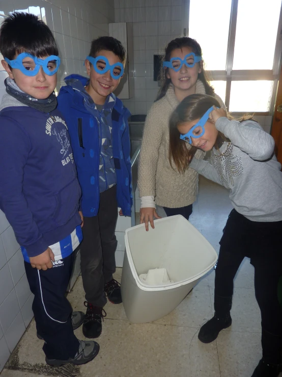 children in blue eye maskes and wearing plastic containers