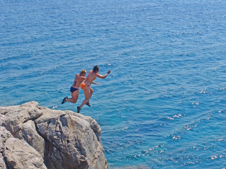 a person jumping in the air near water