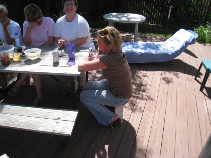 a lady sitting on a deck with friends