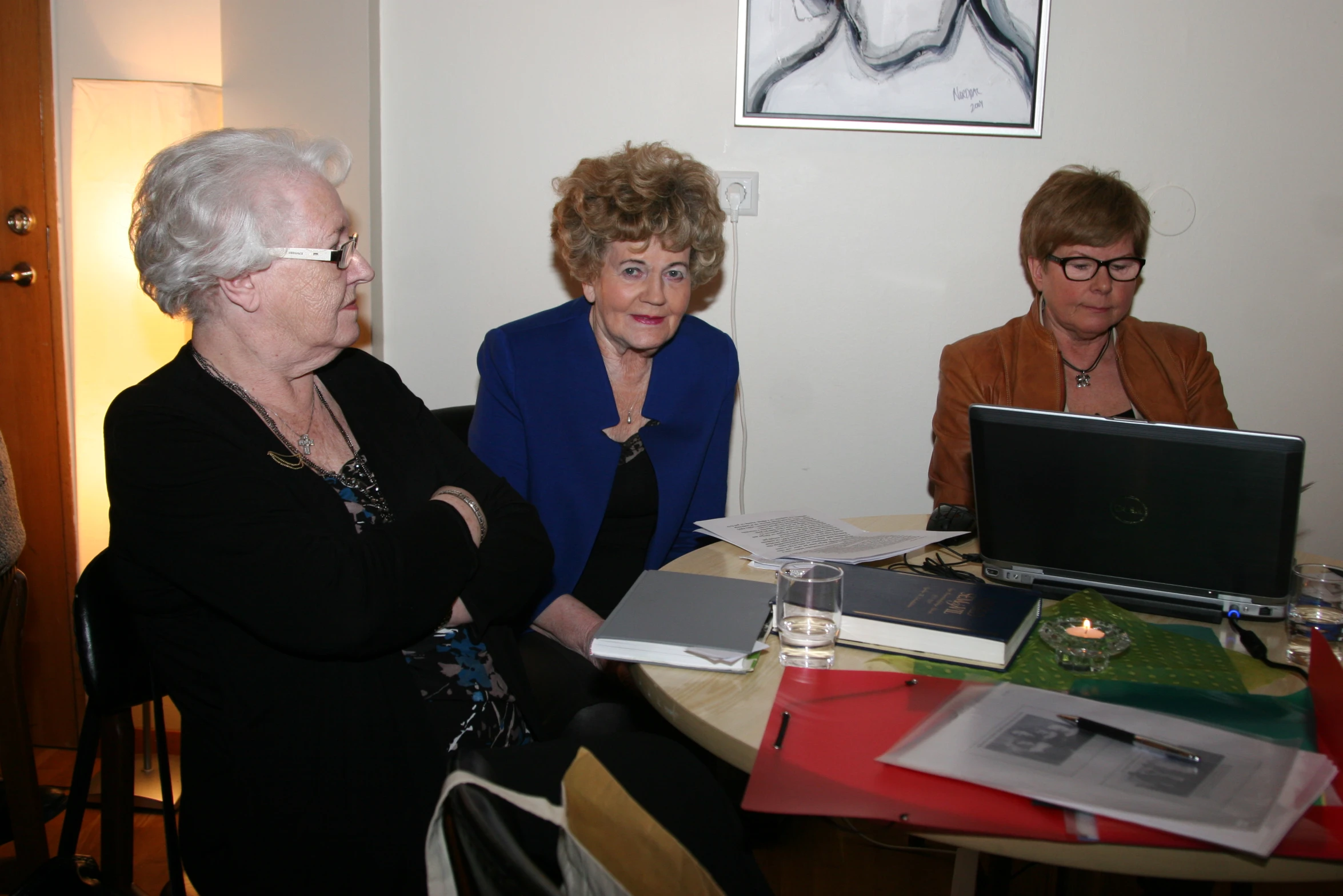 two woman sitting at a table with a laptop computer